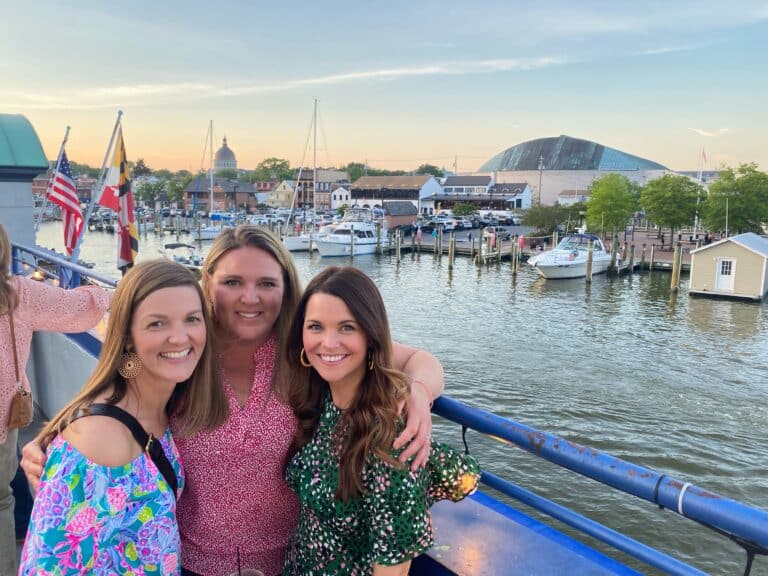 Three women posing together in front of the Annapolis waterfront